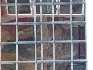 Affreschi visti dall'esterno del portico attraverso la finestrella votiva - Cappella di San Giovanni Evangelista a Centallo